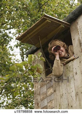 Stock Photo - Boy with binoculars in treehouse. Fotosearch