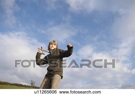 Stock Photograph - Boy with toy plane in countryside. Fotosearch
