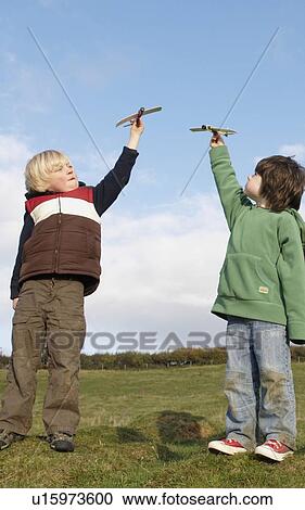 Stock Image - Boys with toy planes in field. Fotosearch