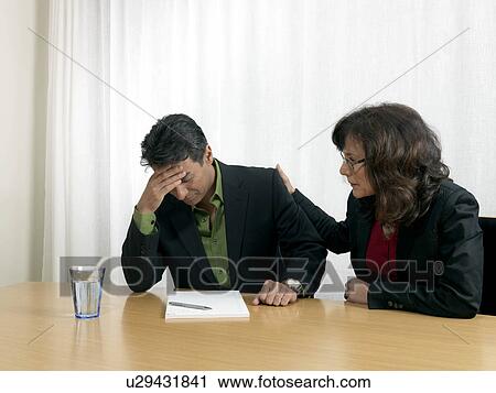 Stock Image - Business colleagues by desk. Fotosearch
