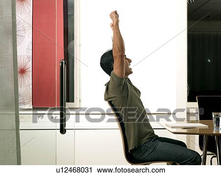 "Business man by desk, cheering" View Large Photo Image Stock Image - "Business man by desk, cheering". Fotosearch