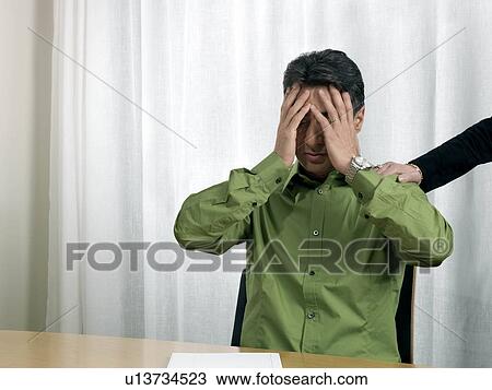 "Business man by desk, hands on face" View Large Photo Image Stock Image - "Business man by desk, hands on face". Fotosearch