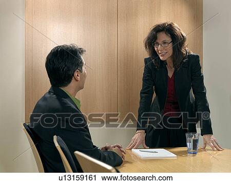 Stock Image - "Business meeting, woman standing". Fotosearch