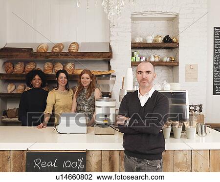 Stock Image - Business owner posing with employees. Fotosearch