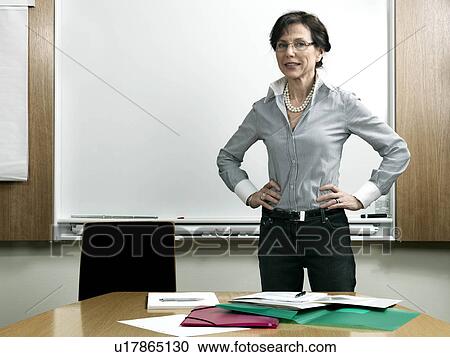 Stock Image - Business woman by conference table. Fotosearch