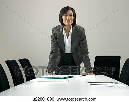 Stock Photograph - Business woman by conference table. Fotosearch