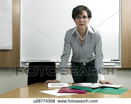 Stock Photo - Business woman by table. Fotosearch