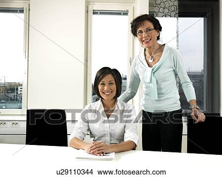 Picture - Business women by conference table. Fotosearch