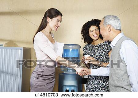 Casual meeting by office water cooler View Large Photo Image Stock Image - Casual meeting by office water cooler. Fotosearch