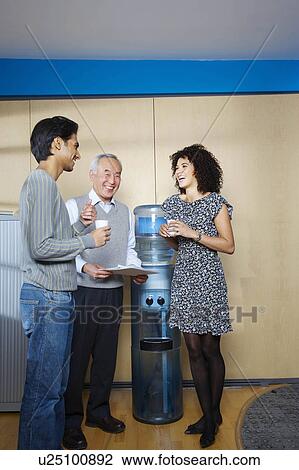 Casual meeting by office water cooler View Large Photo Image Stock Image - Casual meeting by office water cooler. Fotosearch