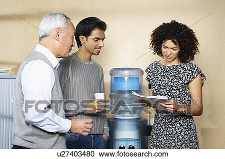 Casual meeting by office water cooler View Large Photo Image Stock Image - Casual meeting by office water cooler. Fotosearch
