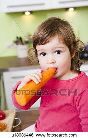 Stock Photograph - Child eating carrot. Fotosearch