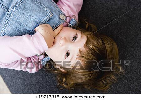 Stock Photography - Child laying on carpet. Fotosearch