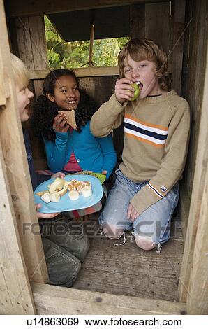 Children having picnic in treehouse View Large Photo Image Stock Photo - Children having picnic in treehouse. Fotosearch