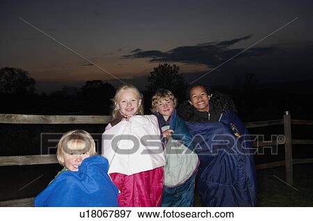 Stock Photo - Children in sleeping bags at dusk. Fotosearch