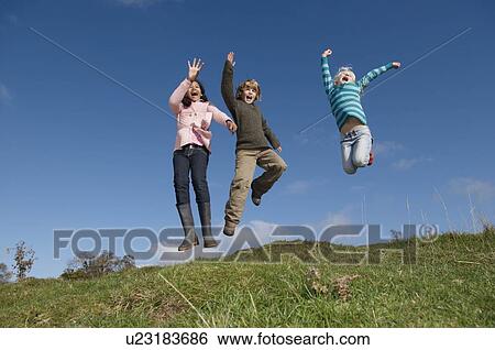 Stock Photograph - Children jumping on hill. Fotosearch