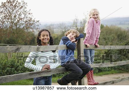 Stock Photo - Children on fence. Fotosearch