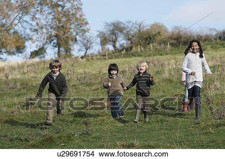 Picture - Children running down hill in field. Fotosearch
