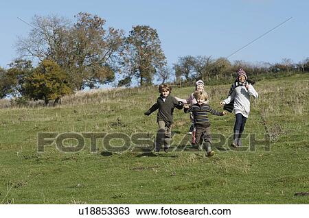 Stock Image - Children running in countryside. Fotosearch
