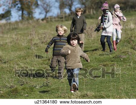 Stock Image - Children running in countryside. Fotosearch