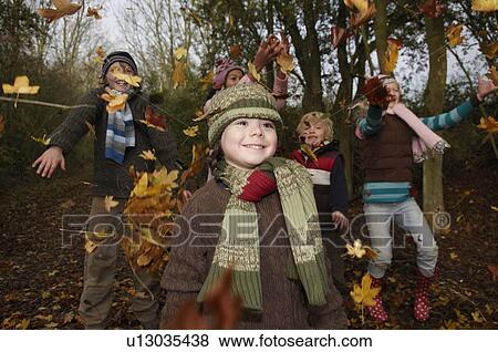 Children throwing autumn leaves View Large Photo Image Stock Photo - Children throwing autumn leaves. Fotosearch