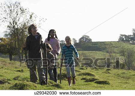 Stock Image - Children walking in field. Fotosearch