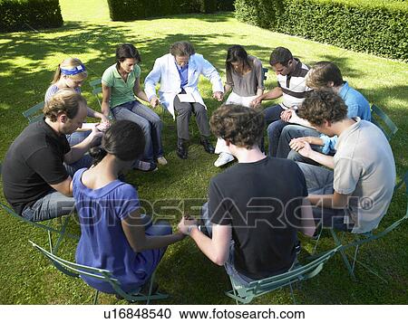 Stock Image - "Circle of people in rehab, holding hands". Fotosearch