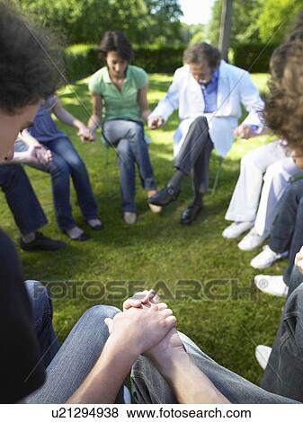 Stock Photo - "Circle of people in rehab, holding hands". Fotosearch