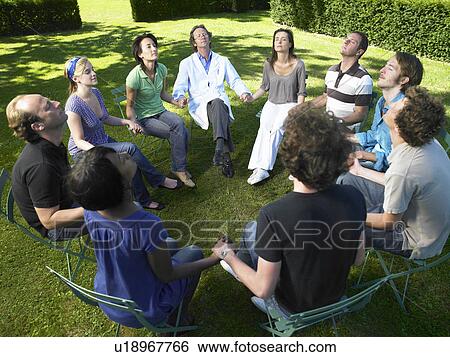 Stock Photograph - "Circle of people in rehab, holding hands". Fotosearch
