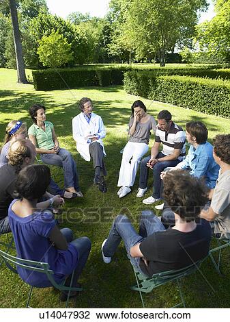 Stock Image - "Circle of people in rehab, outdoors". Fotosearch