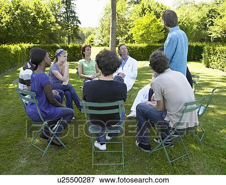 Stock Photo - "Circle of people in rehab, outdoors". Fotosearch