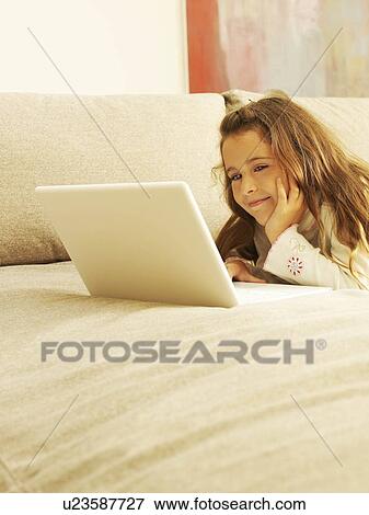 Close up of girl on sofa with laptop View Large Photo Image Stock Photo - Close up of girl on sofa with laptop. Fotosearch