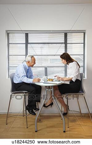 Co-workers at cafe table with laptop View Large Photo Image Stock Image - Co-workers at cafe table with laptop. Fotosearch