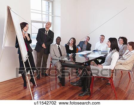 Co-workers giving presentation in office View Large Photo Image Stock Image - Co-workers giving presentation in office. Fotosearch