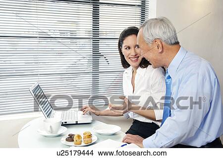Co-workers in cafe with laptop smiling View Large Photo Image Picture - Co-workers in cafe with laptop smiling. Fotosearch