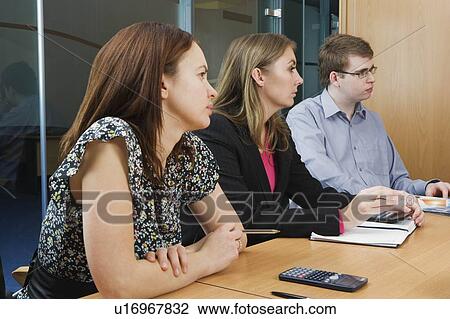 Stock Image - Colleagues at meeting in boardroom. Fotosearch