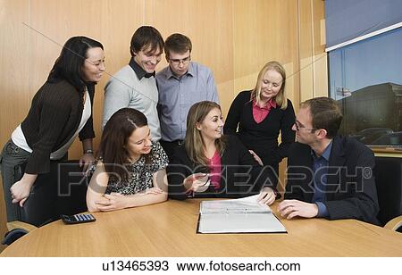 Stock Image - Colleagues having meeting in boardroom. Fotosearch