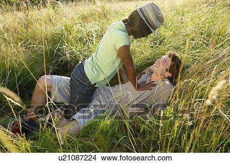 Picture - Couple fooling around in a field. Fotosearch