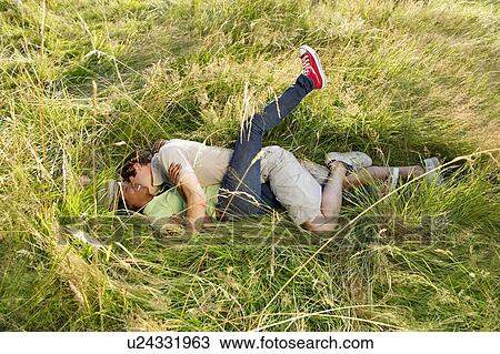 Stock Image - Couple fooling around in a field. Fotosearch