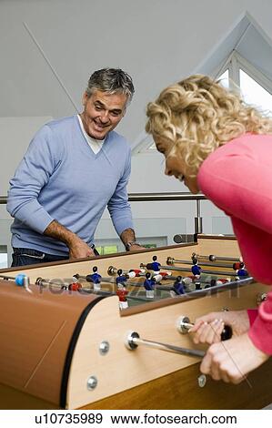 Couple having fun playing table football View Large Photo Image Stock Photo - Couple having fun playing table football. Fotosearch