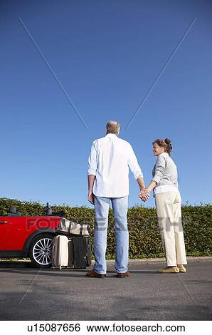 Couple holding hands by car View Large Photo Image Stock Photograph - Couple holding hands by car. Fotosearch