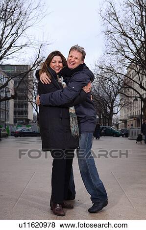 Stock Photo - "Couple hugging, laughing". Fotosearch