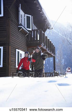 Couple in front of chalet with their ski View Large Photo Image Stock Image - Couple in front of chalet with their ski. Fotosearch