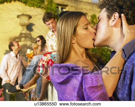 Couple kissing at a cocktail party View Large Photo Image Stock Image - Couple kissing at a cocktail party. Fotosearch