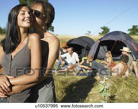 Stock Photography - "Couple kissing, backpacking tents". Fotosearch