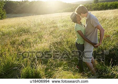 Couple kissing in a field View Large Photo Image Picture - Couple kissing in a field. Fotosearch