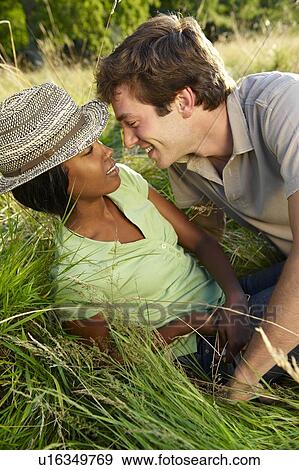 Stock Photo - Couple kissing in a field. Fotosearch