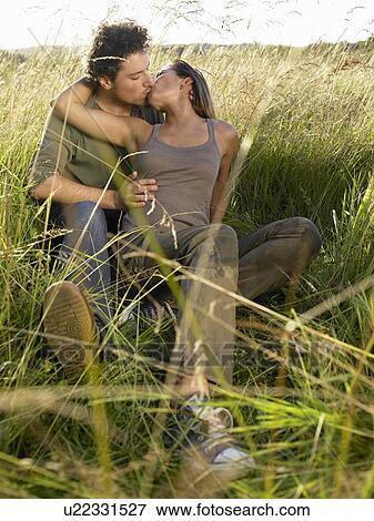 Stock Photo - Couple kissing in a field. Fotosearch