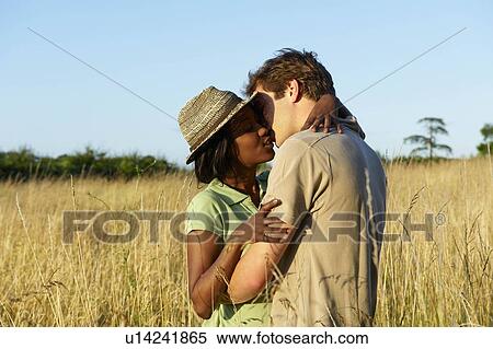 Couple kissing in a field View Large Photo Image Stock Photography - Couple kissing in a field. Fotosearch