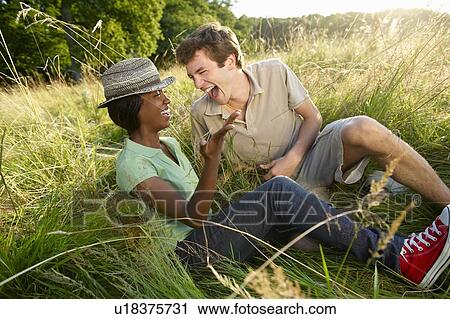 Stock Image - Couple laughing in a field. Fotosearch